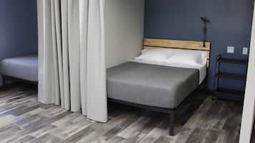 A bedroom with a bed, a bench, a nightstand, and a wall-mounted light.