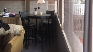 A small, enclosed room with a table and chairs, a sofa, and a window with a view of the outside. - Beachfront Summer Rental- Sea Cliff (Sea Cliff)