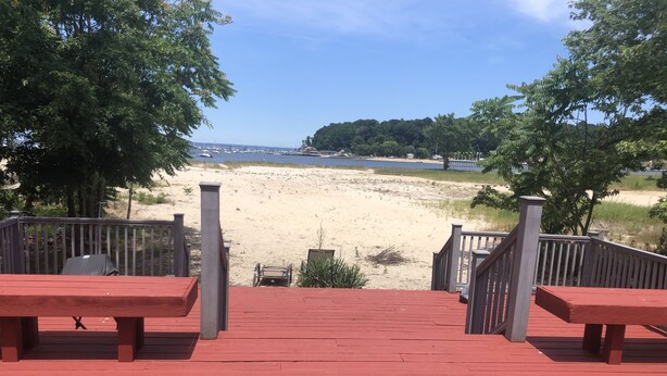 A wooden deck with red railings leading to a sandy beach area. - Beachfront Summer Rental- Sea Cliff (Sea Cliff)