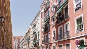 Una hilera de edificios de varios pisos con balcones, aire acondicionado y toldos.