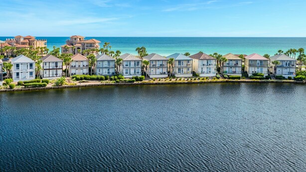 A waterfront property with multiple two-story buildings, a marina, and a large ocean view. - Destiny Beach Villas 2B - Gulf Views, Community Pool, Steps to the Beach! (Destin)
