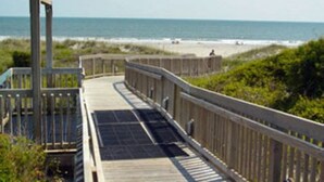 A wooden boardwalk leading to a beach with a clear view of the ocean. - 2024 Totally Renovated Oceanview condo Indoor/Outdoor Pool, 150' Waterslide Wifi (Atlantic Beach)