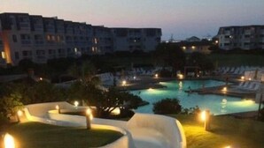 A water slide at a resort with pools and a view of surrounding buildings. - 2024 Totally Renovated Oceanview condo Indoor/Outdoor Pool, 150' Waterslide Wifi (Atlantic Beach)