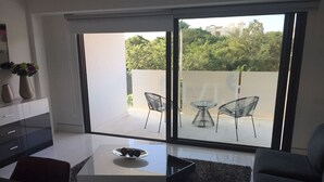 Un salon moderne avec une table basse en verre, un canapé et un coin repas.