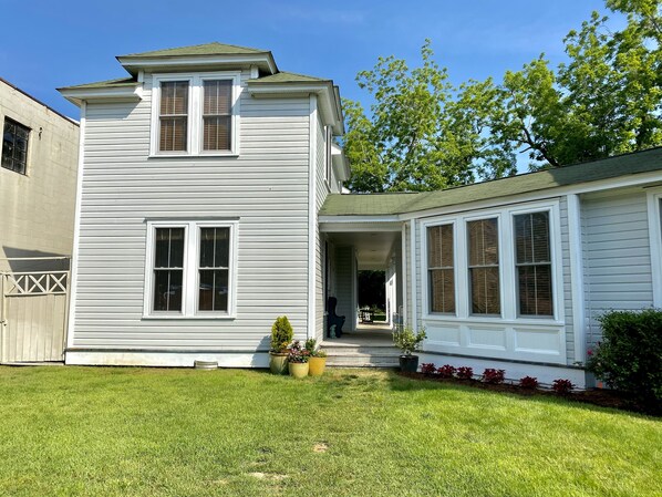 A two-story house with a covered porch and a small front yard. - Downtown Manteo with Secret Garden (Manteo)