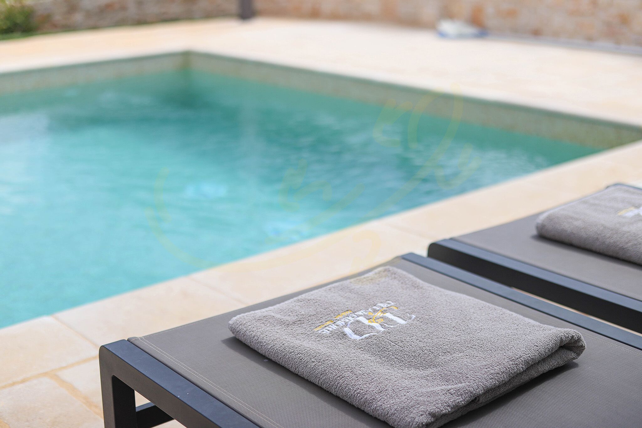 A poolside area with lounge chairs and towels.