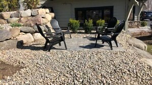 A patio with outdoor furniture and a stone wall. - Lake view cozy two bedroom in Bolton Landing -  walk to Town! (Bolton)