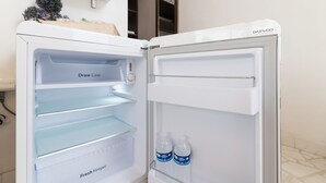 A white refrigerator with a "Draw Case" and "Fresh Keeper" compartments, containing two water bottles. - Healing Roof Terrace (Playa del Carmen)
