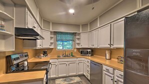 A modern kitchen with white cabinets, stainless steel appliances, and a wooden countertop. - Lake O’ the Pines Family Getaway (Avinger)
