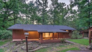 A wooden cabin with a porch, surrounded by a wooded area. - Lake O’ the Pines Family Getaway (Avinger)
