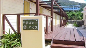 A wooden deck leading to a building with a sign in Japanese. - Asobi Base Yamabare House Ishigakijima (Ishigaki)