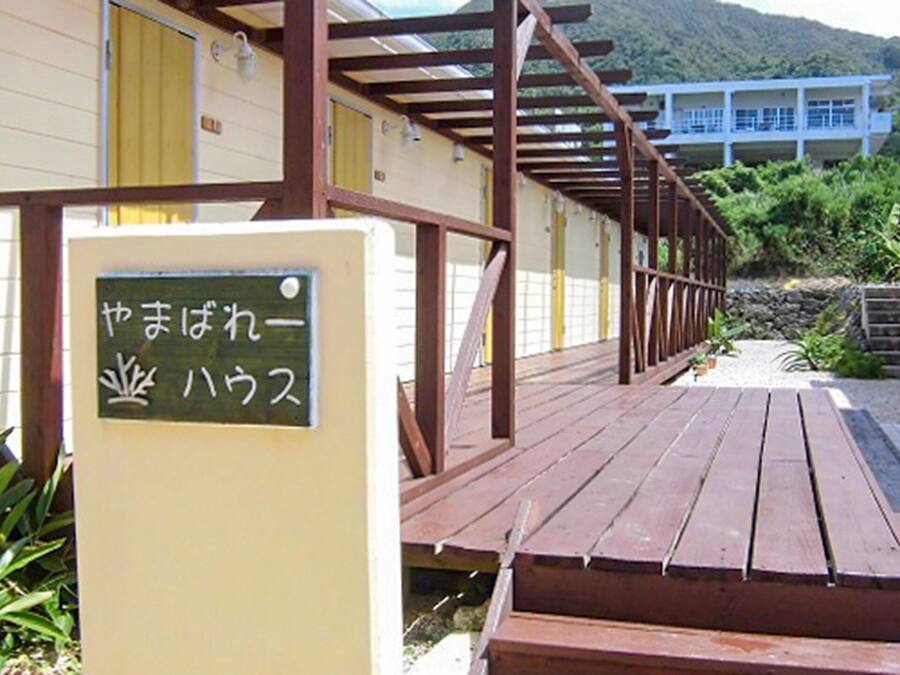 Um deck de madeira que leva a um edifício com uma placa em japonês.