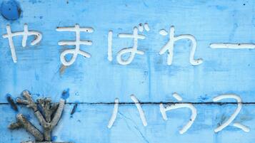 Un panneau bleu avec des caractères japonais blancs et un décor évoquant des coraux.