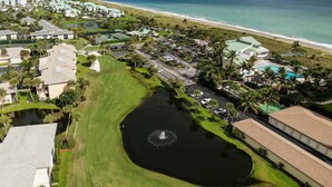 A resort with a golf course, a central pond, and a beach view. - OV 317 Golf/Pond View Condo - Paradise Vacation Rental in Ocean Village (FORT PIERCE)