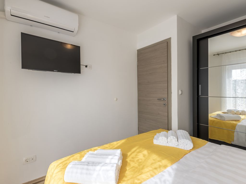 Une chambre d’hôtel équipée d’un lit, d’un téléviseur à écran plat, d’un climatiseur et d’une armoire.