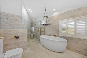 Bathtub, hair dryer, towels, shampoo