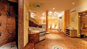 Une salle de bain spacieuse avec une grande baignoire, un espace douche et un sol carrelé.