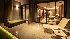 A modern hotel room with a glass shower enclosure, a seating area with a table and chairs, and a visible bathroom with a bathtub. - Kamenoi Hotel Aso (Aso)