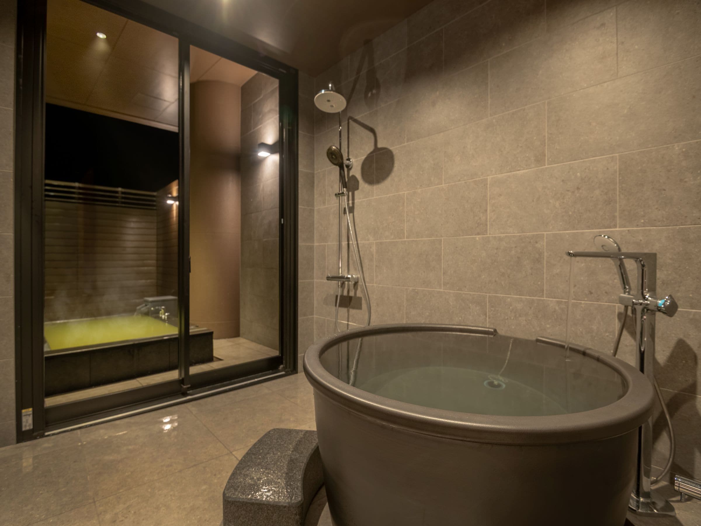 A modern bathroom with a large glass-enclosed jacuzzi, a separate shower area, and a bathtub.