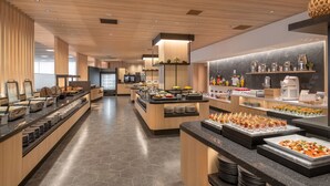 A modern buffet setup with various food stations and a kitchen area in the background. - Kamenoi Hotel Aso (Aso)