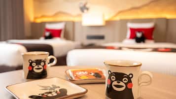A hotel room with two beds, a bedside table with a mug and a plate, and a lamp.