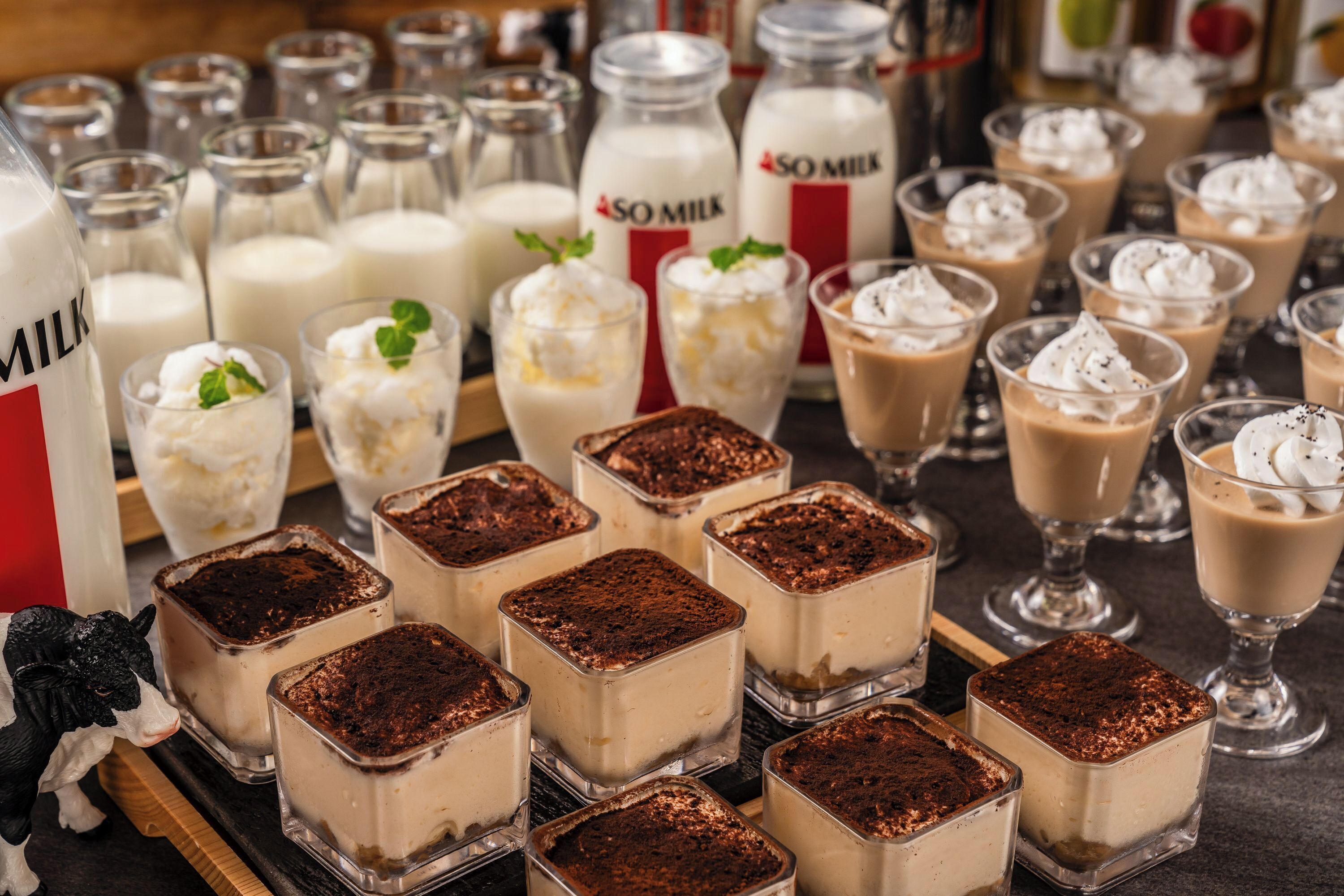 Una variedad de postres y botellas de leche sobre una bandeja.