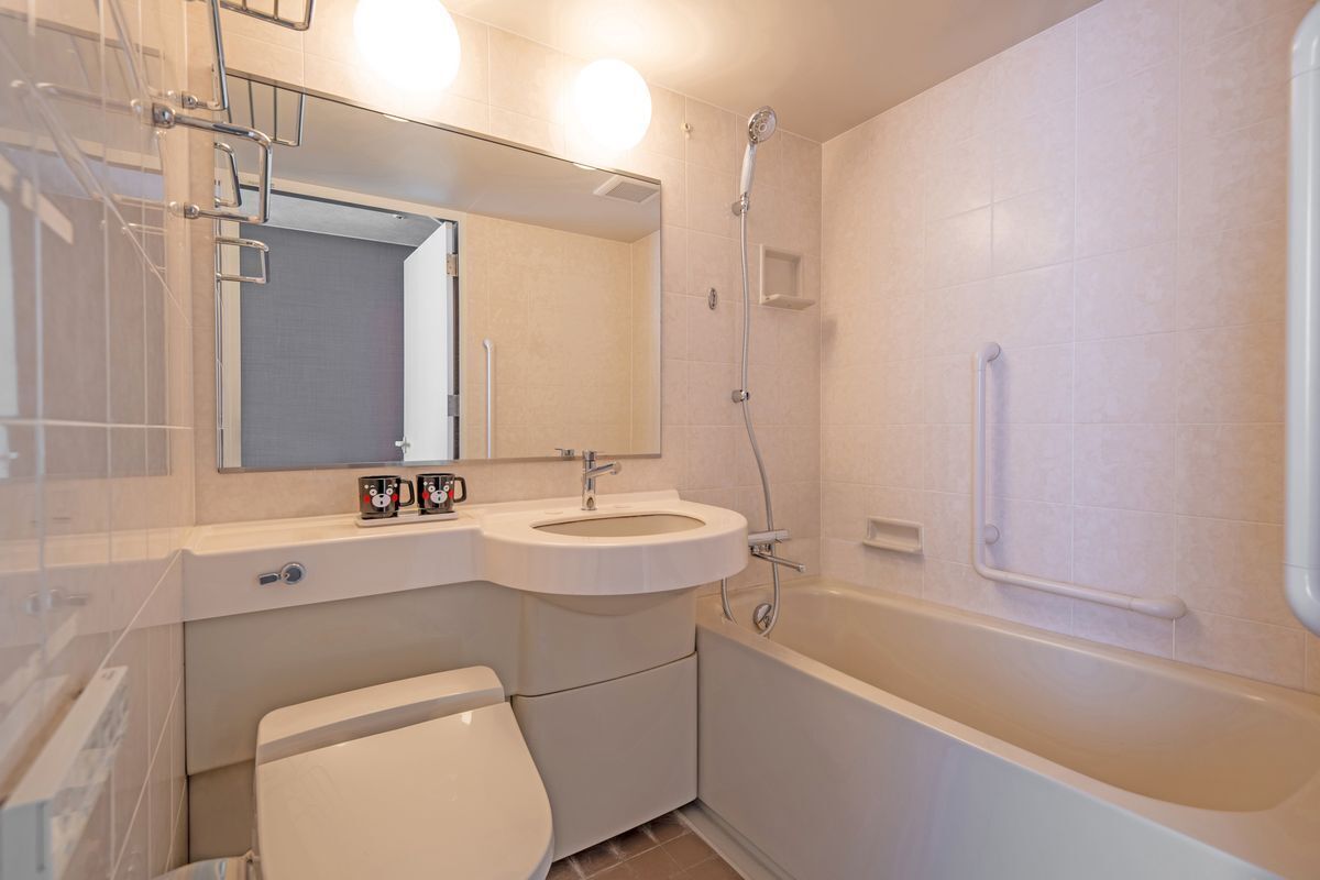A modern bathroom with a toilet, sink, and bathtub.