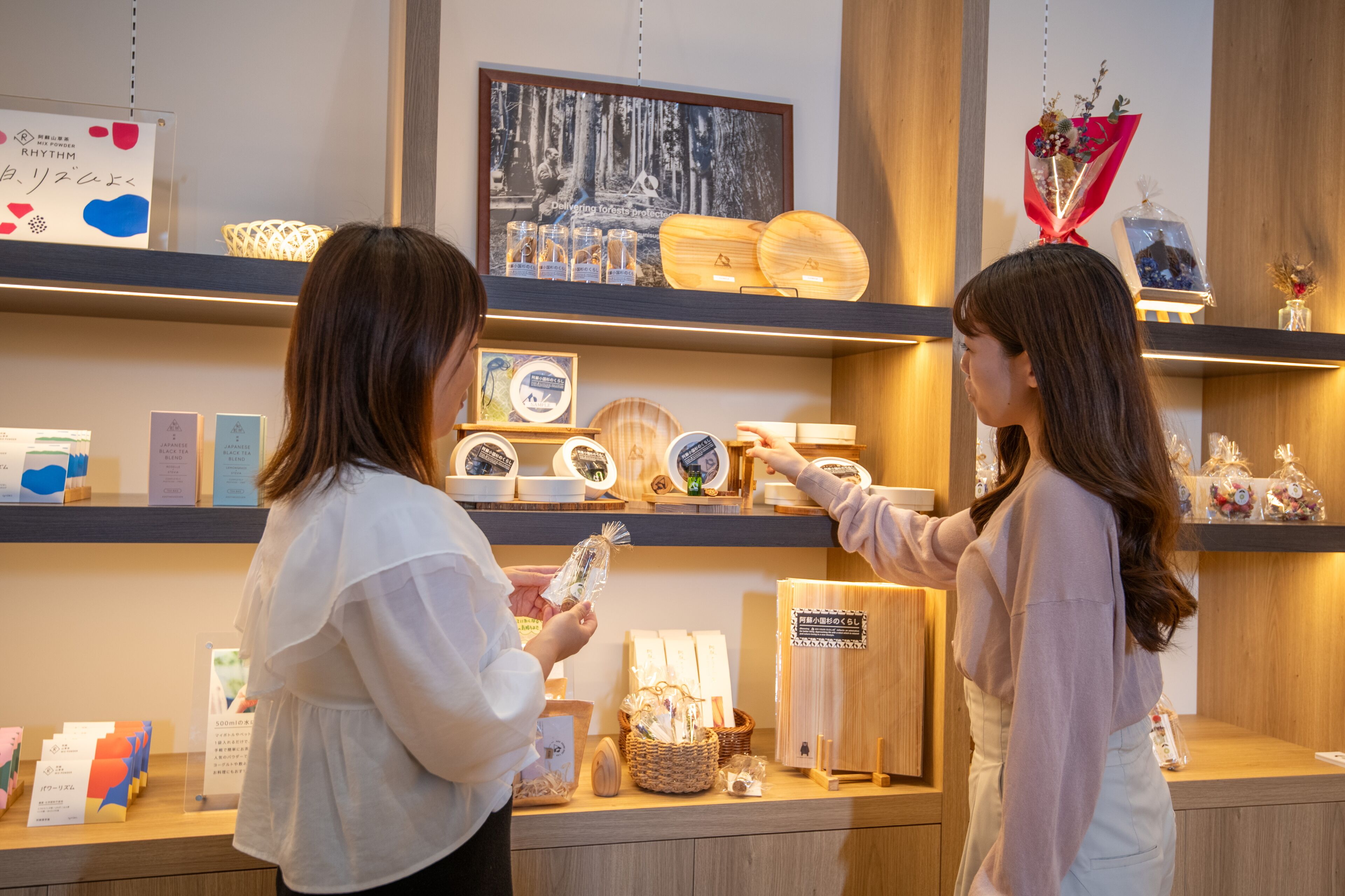 A retail display with various items on shelves, including framed pictures, wooden objects, and decorative items.