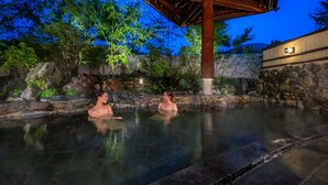 A hot spring area with a wooden pavilion and stone walls. - Kamenoi Hotel Aso (Aso)