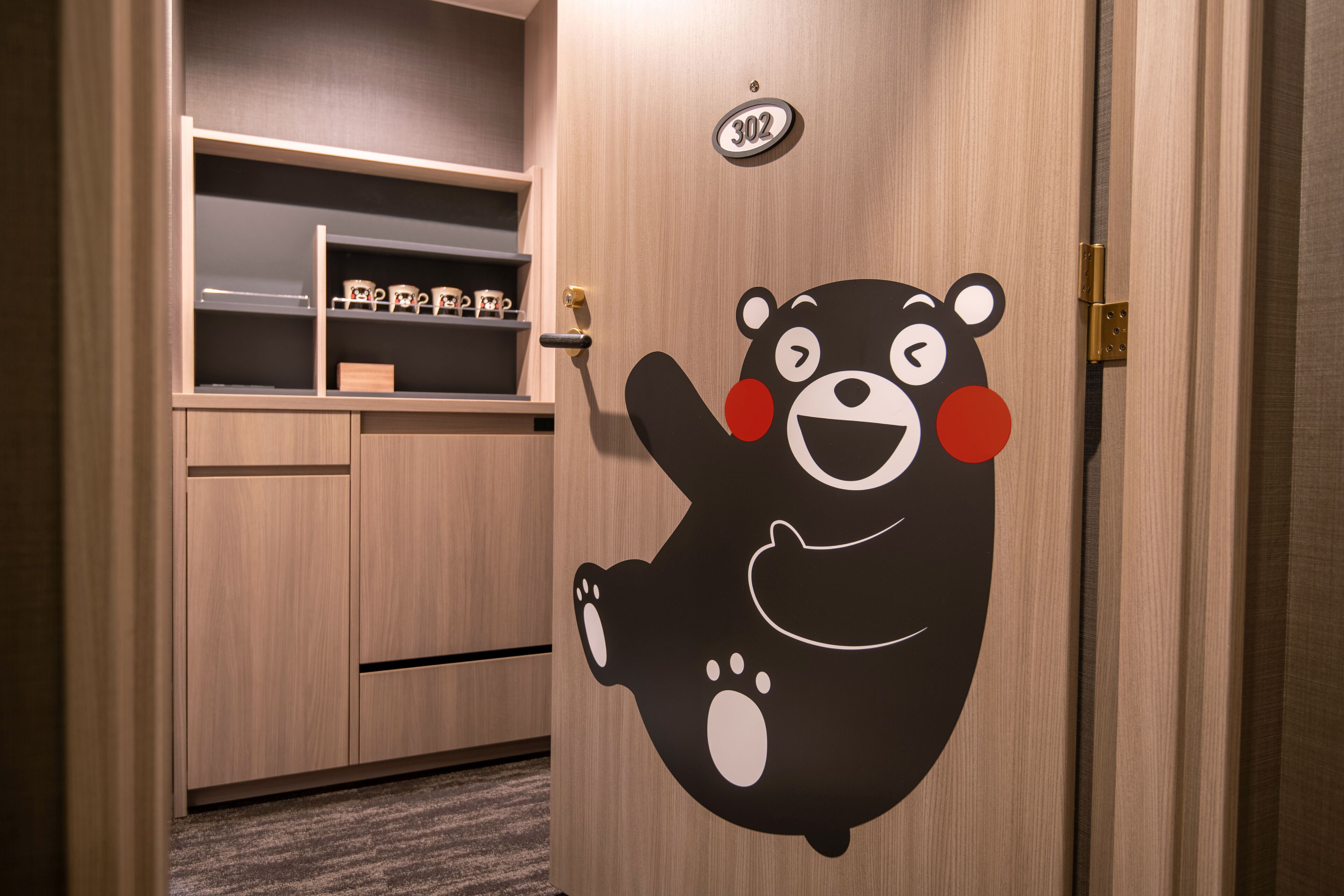 Una puerta de madera con una etiqueta de oso, un letrero con número y un estante con objetos.