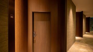 A hallway with a wooden door, numbered 103, leading to a room.