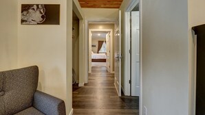 A hallway with a patterned sofa, wooden flooring, and a bed in the distance. - 4 Master Suites in the Heart of Alaska...Abby's Place..... (Palmer)