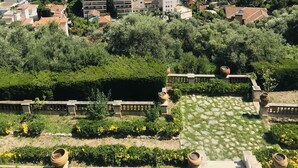 Une ville côtière avec des bâtiments, de la verdure et une vue sur la mer.