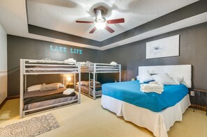 Ein Schlafzimmer mit Etagenbetten, einem großen Bett, einem Deckenventilator und einem Wandschild mit der Aufschrift 'LAKE LIFE'.