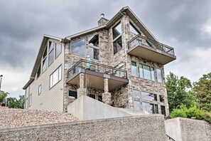 Ein mehrstöckiges Haus mit einer Steinaußenwand, großen Fenstern und einem Balkon.