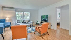A modern living room with a sofa, chairs, a coffee table, and a TV. - Downtown Home w/ Patio - Walk to Shops & Dining! (Stevenson)