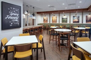 Enjoy meals in a stylish dining area with individual tables and booths, surrounded by artwork and recessed lighting.