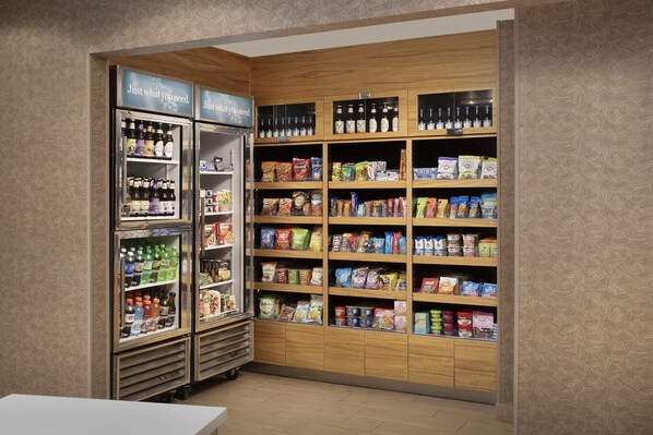A snack and beverage kiosk with refrigerated drinks and shelves stocked with snacks and beverages.