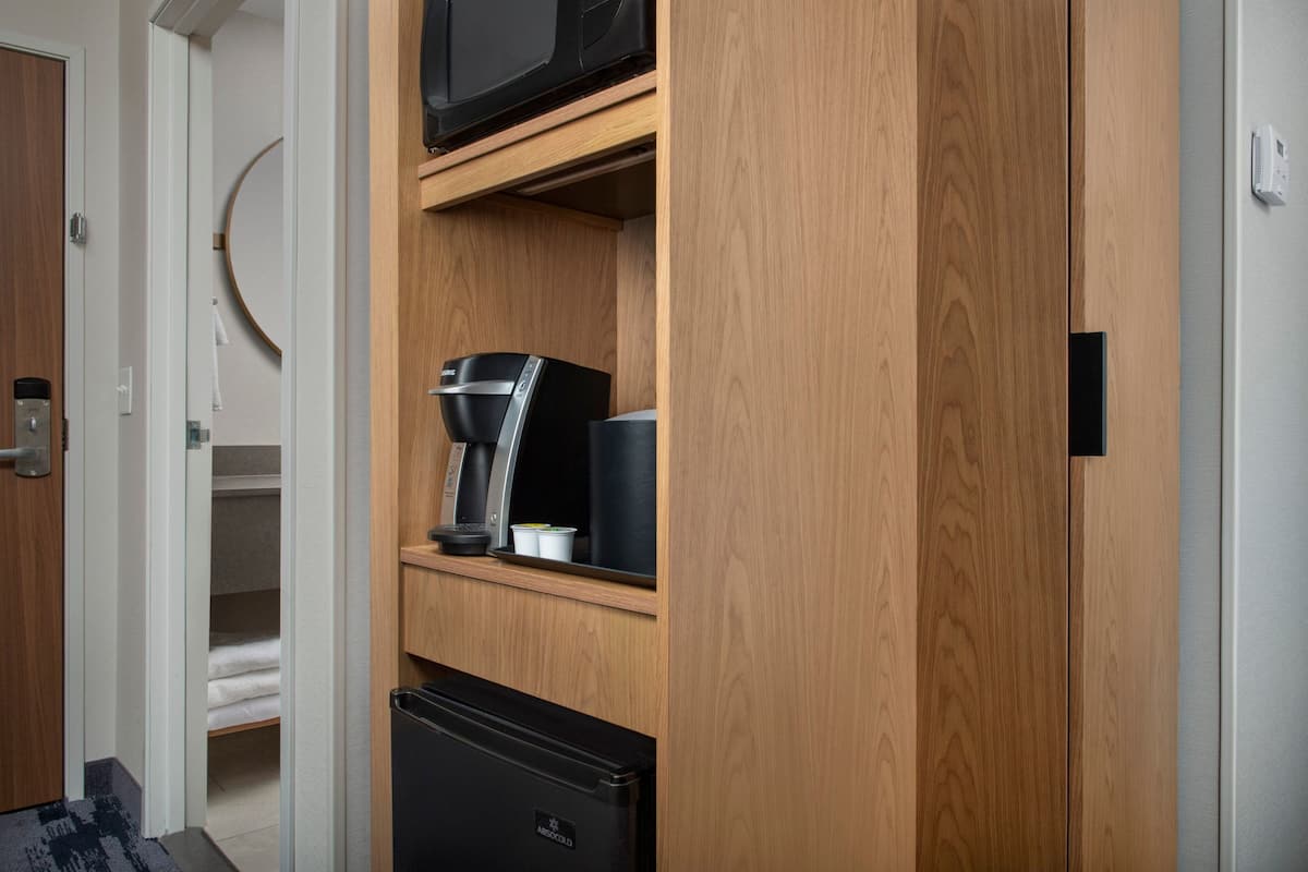 A compact kitchenette with a coffee maker, a microwave, and a refrigerator.
