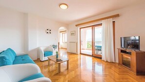 Una sala de estar moderna con un sofá, una mesa de centro y un mueble para televisión.