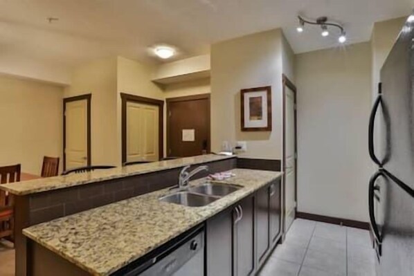 A kitchen with granite countertops, stainless steel appliances, and a built-in oven.