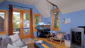 A living room with a sofa, television, and a fireplace. - The Surf Shack, On shuttle route, EV charger (Crested Butte)