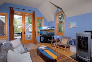 A living room with a sofa, television, and a fireplace. - The Surf Shack, On shuttle route, EV charger (Crested Butte)