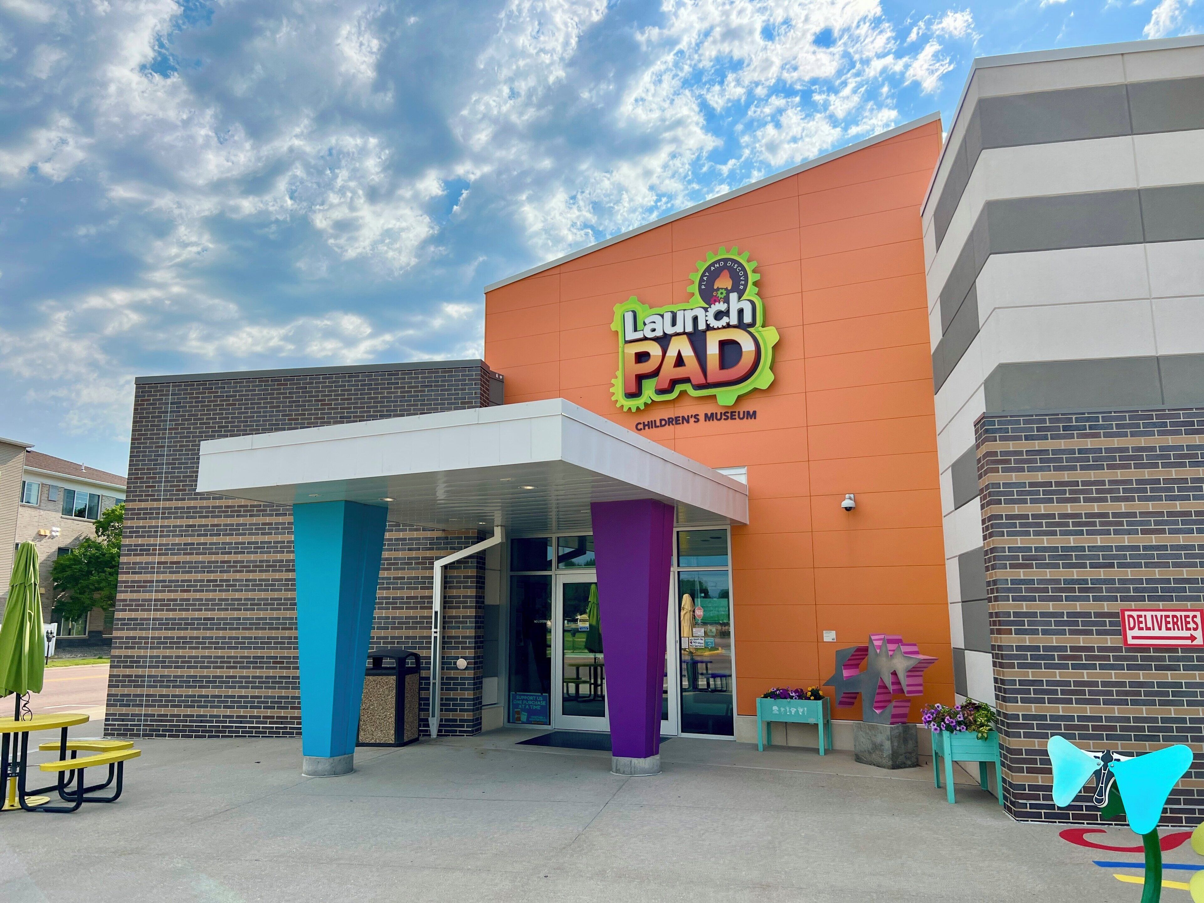 A children's museum with a colorful entrance and a sign reading 'Launch PAD.'