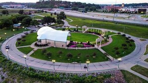 A large, dome-shaped building with a glass exterior, surrounded by a landscaped area with pathways and lamp posts.