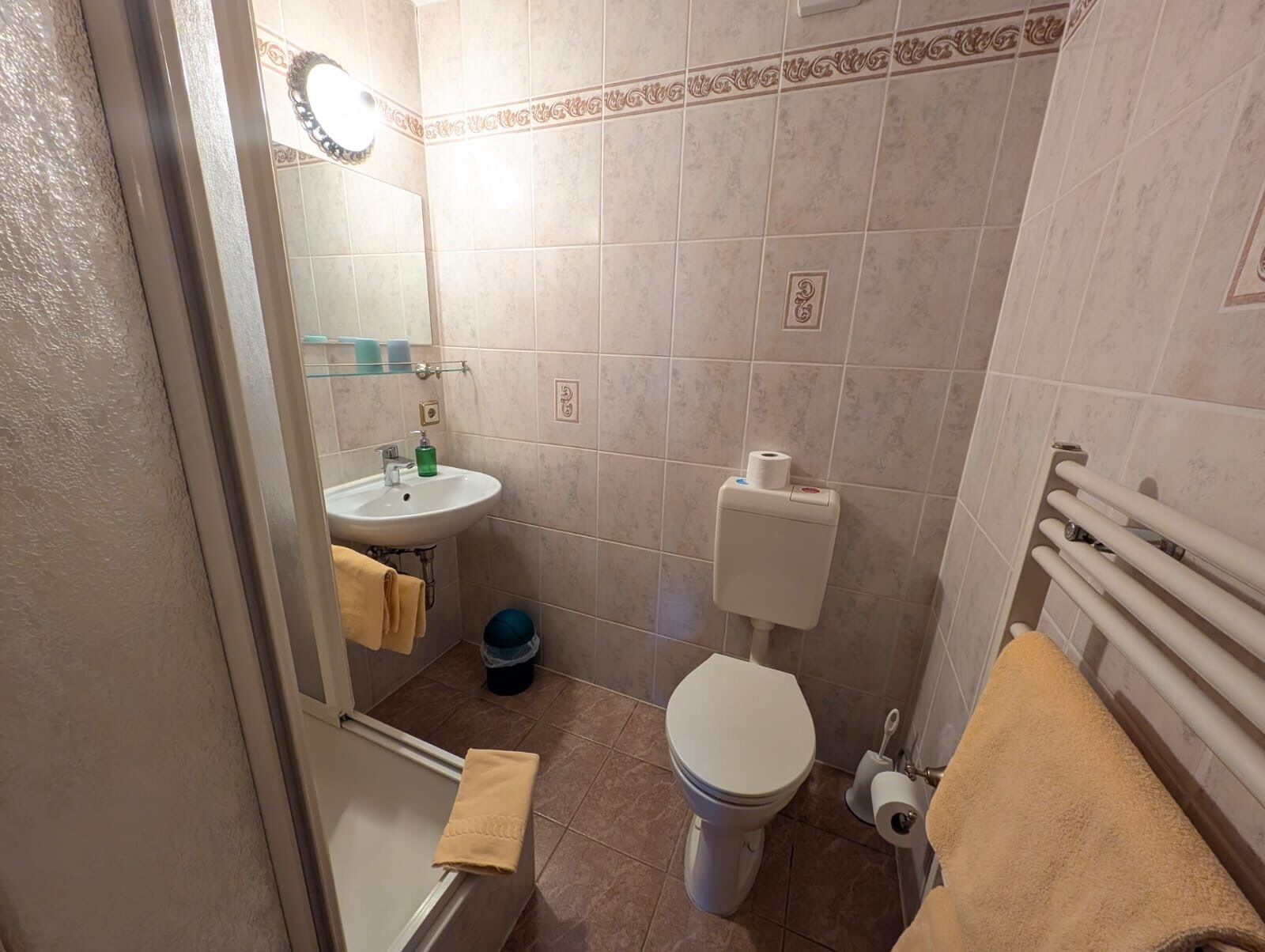 Un baño pequeño con lavamanos, inodoro y toallero.