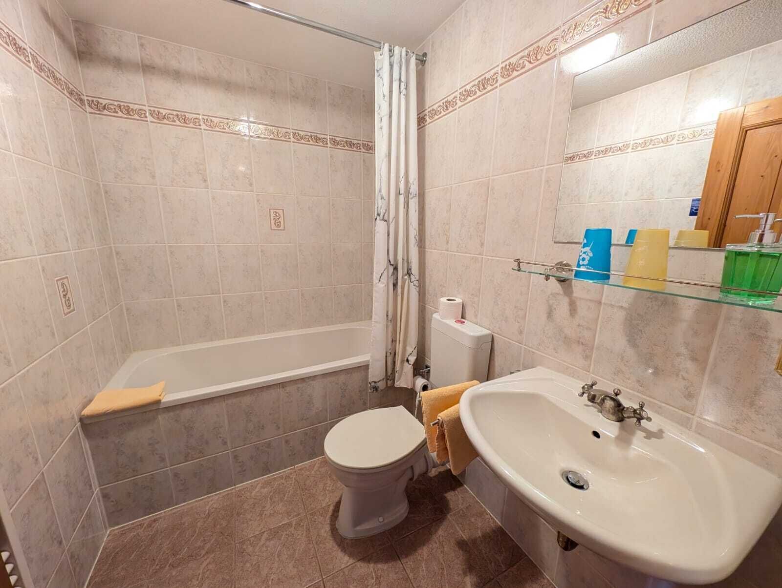 A bathroom with a bathtub, toilet, and sink.