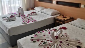 A hotel room with two beds, each adorned with a towel swan and rose petals. - Side Ozgurhan Hotel (Manavgat)