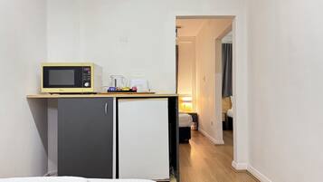 Ein kleines Hotelzimmer mit Küchenzeile, einem Bett und einem kompakten Badezimmer.