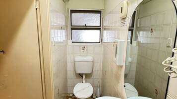 Un baño pequeño con inodoro, lavamanos y ventana.